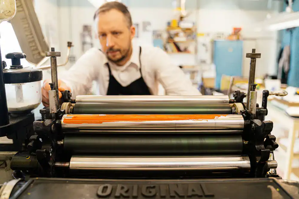 Student operating a vintage letterpress machine